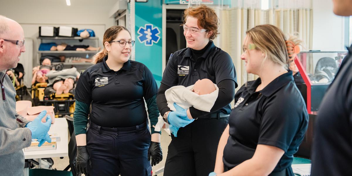 EMT students with mannekin baby.